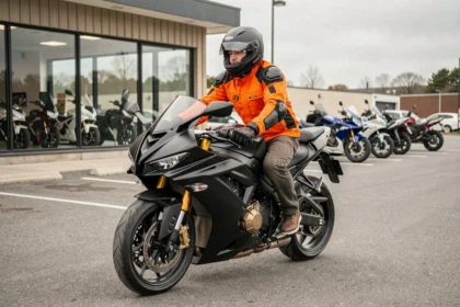 Jeune motard débutant assis sur une moto sportive puissante devant un concessionnaire moto